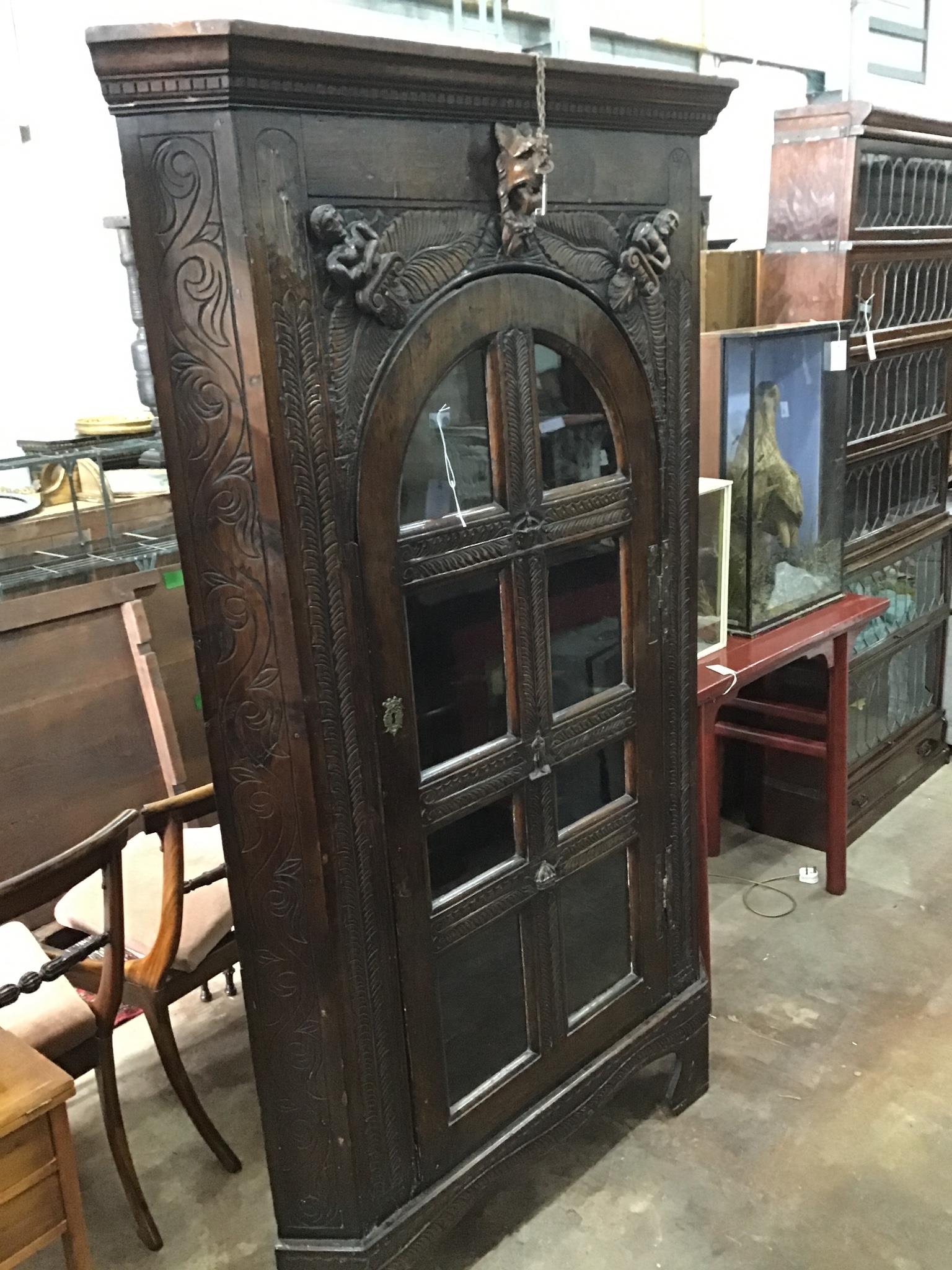 An 18th century style carved oak standing corner cabinet , width 112cm, depth 46cm, height 197cm.